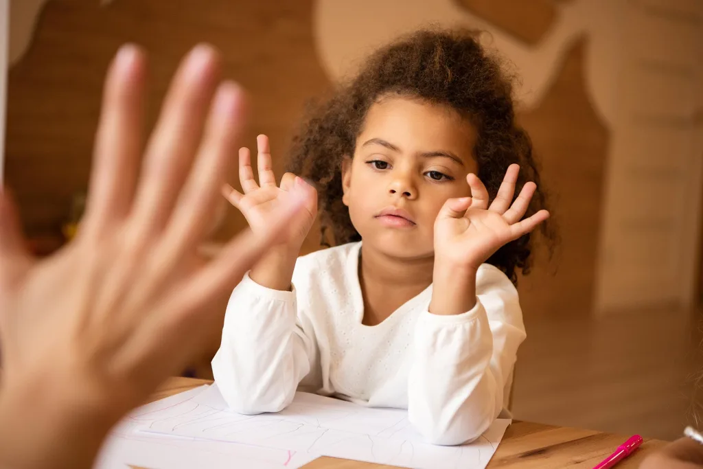 Niña jugando con su terapeuta usando sus manos,  La importancia del juego en la terapia infantil