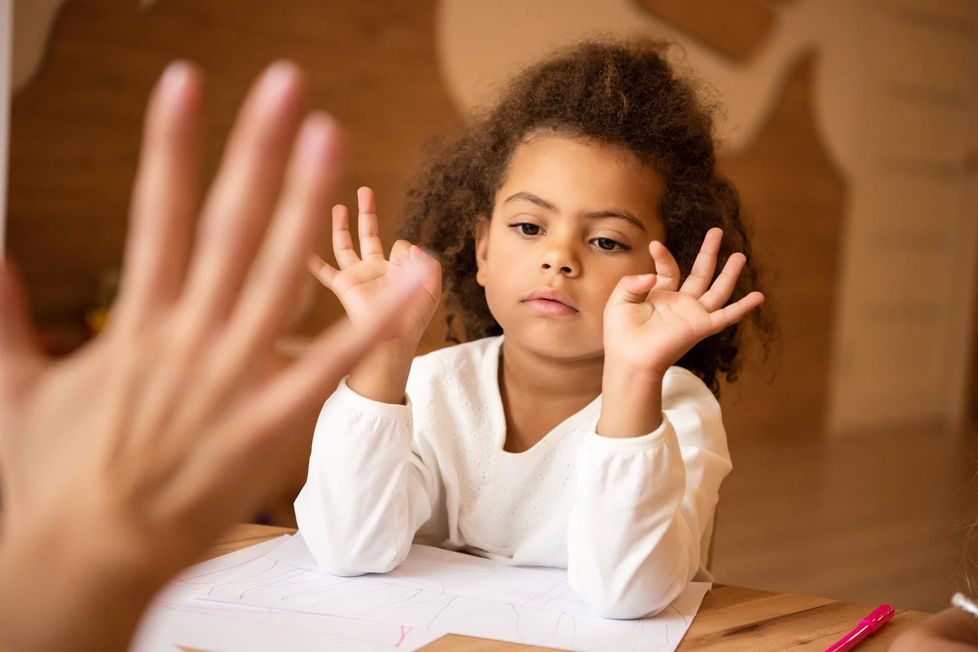 Niña jugando con su terapeuta usando sus manos, La importancia del juego en la terapia infantil